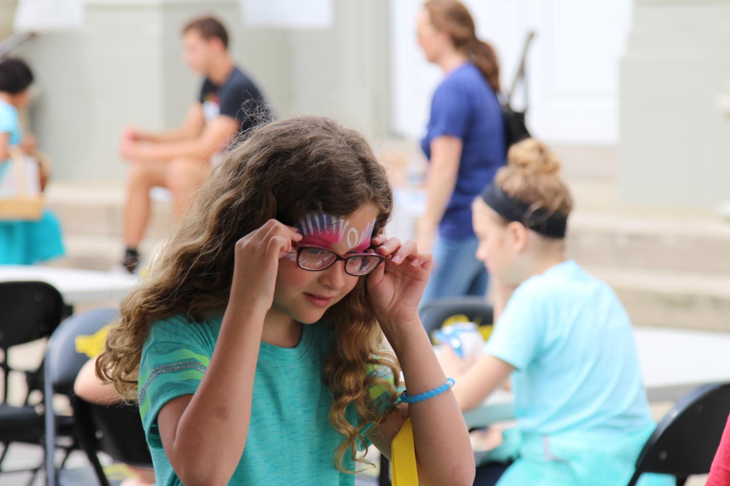 A young girl gets her face painted at Spark 