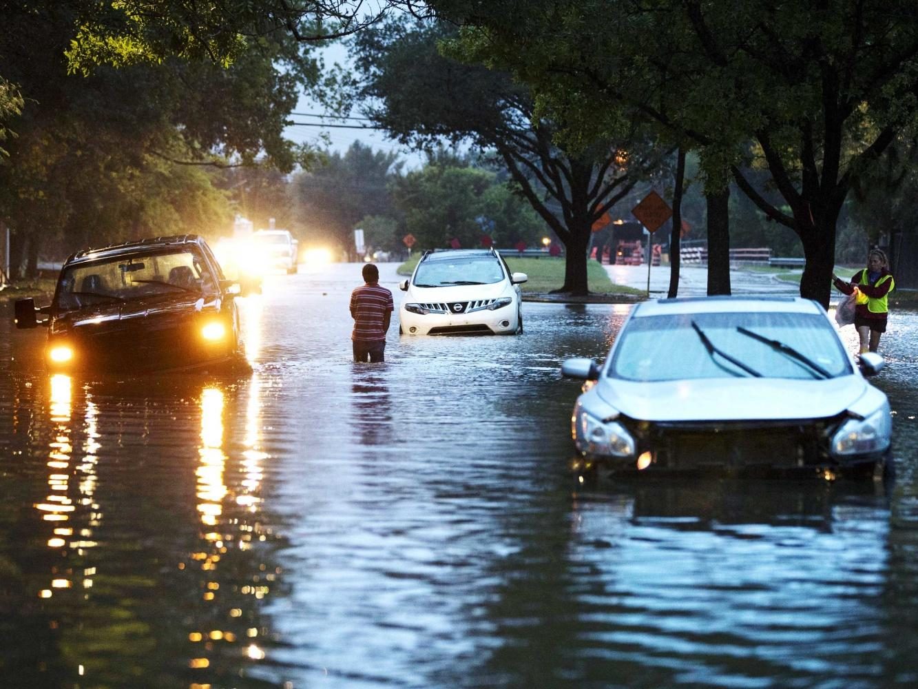 Hurricane Harvey 2017. Residents walking through high water,  and past stranded cars. (Image Source ERICH SCHLEGEL/GETTY IMAGES.)
