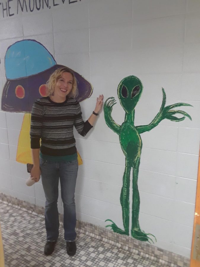 Ms. Schwarz standing next to the alien she highlighted