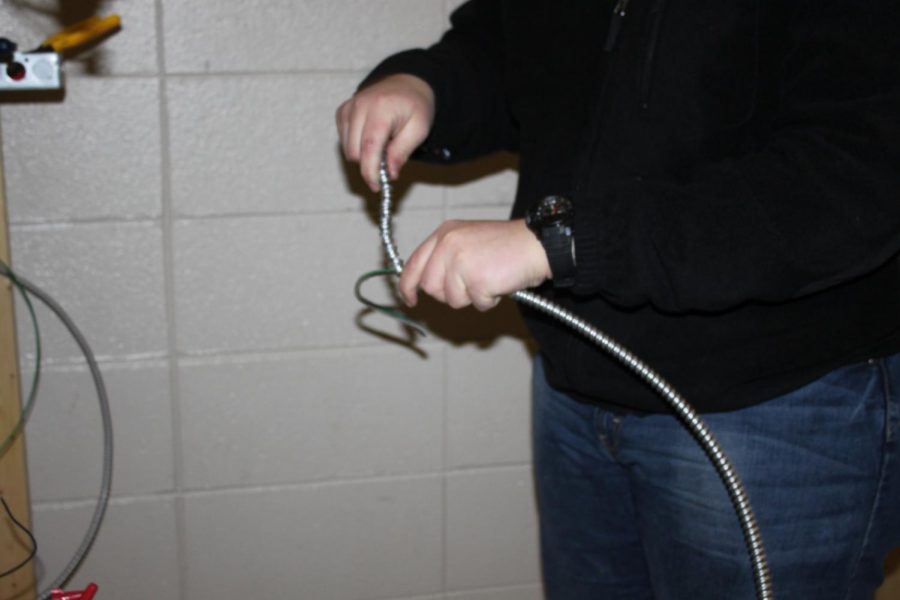 Aaron Strugilee (11) grounds an electrical wire. 