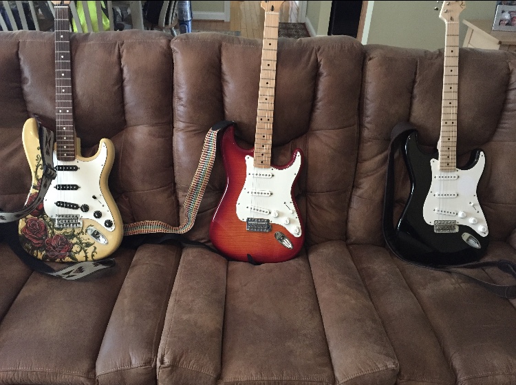 Three Stratocasters on a couch 