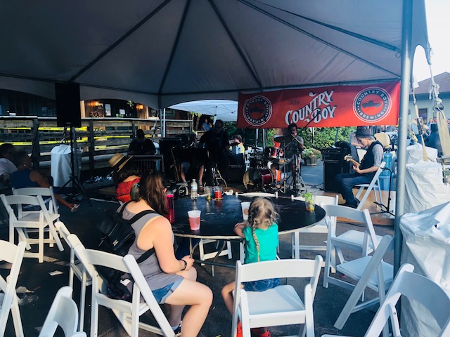 People enjoying their time while eating and listening to local bands.