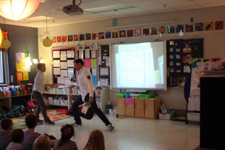 He demonstrates to kids how to fence with the help of a student. 