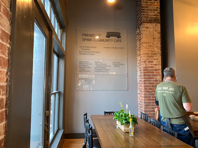 On the left wall of the main room, a large placard features the names of sponsors of the cafe.
