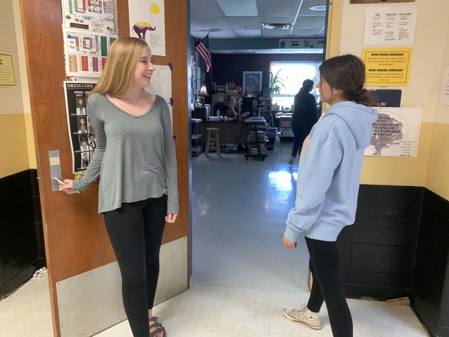 Ashlyn Martin (11) invites Anna Ward (10) into a classroom. 