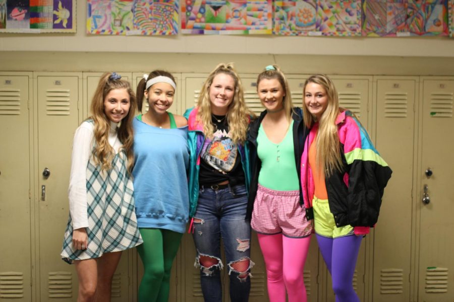 Seniors Casey Montgomery, Karigan Smith, Abbey Moffett, Kasey Abel, and Gabby Blakenship pose for a picture against the lockers in their best 80s attire.