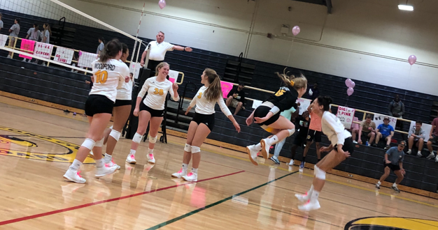 The JV team celebrates a point in the three set thriller. 