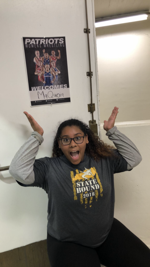 Senior (12) MaQuoia Bernabe posing in front of a welcome poster with her name on it. 