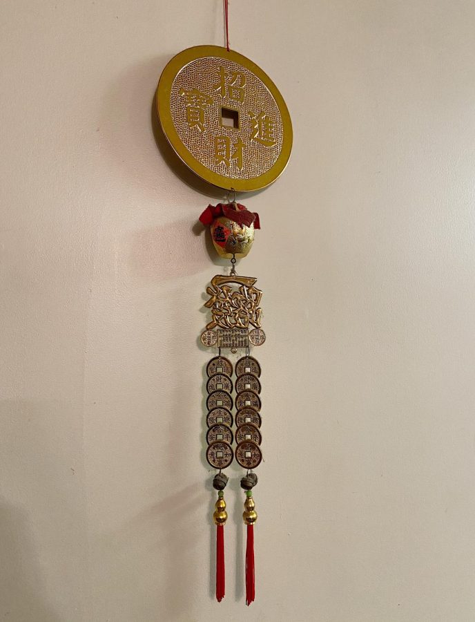 The wall decoration describes how to obtain treasure and has double strands of gold coins dangling down symbolizing wealth.