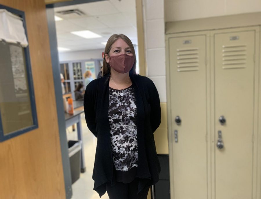 Ms. Wiley, standing outside of her classroom in the science hallway. 