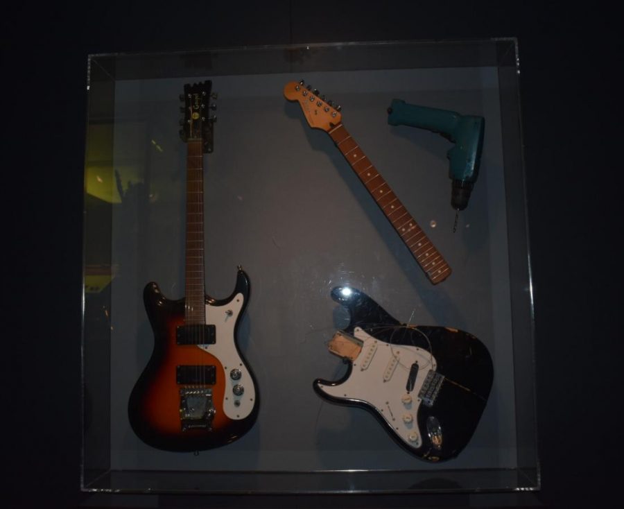 These are two of Kurt Cobains electric guitars and a drill. On the right is 1960s Mosrite Gospel Guitar, one of Kurts favorite guitars. It is one of the few Mark V style Mosrite Gospel models. Kurt owned and smashed many copies of Mosrite guitars, but this one was one of two authentic Mosrites he owned, so it escaped the fate of the other guitars that he used in live performances. On the left is a Fender Stratocaster, which he smashed during a Nirvana concert in 1993, he ran off to the side of the stage and grabbed a drill, and proceeded to drill a hole in the bridge pickup on stage in an attempt to impress Eddie Van Halen, who was standing on stage left.