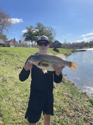 Bass Fishing team member shows off his large mouth bass. 
