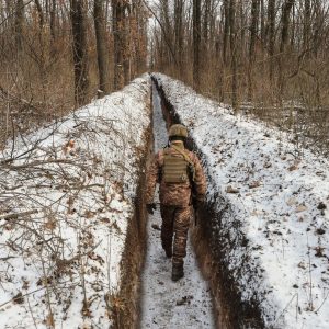 Ukrainian soldier pacing the trench carved along the line of contact in the separatist held Donetsk region.