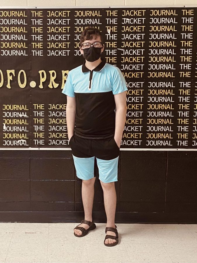 A photo of Jayden Oakley standing in front of a board that repeats the phrase jacket journal