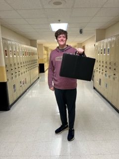Elijah Martin (11) holds up his briefcase with a big smile for anything but a backpack day. 