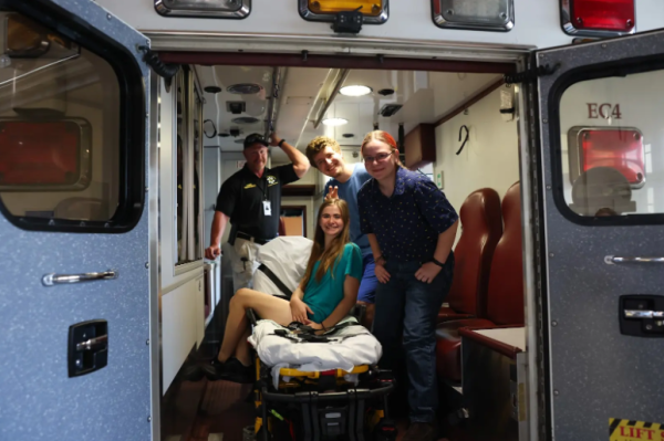 EMT Students Dani Kirchhof, Wyatt Richards, and Ella Clark-Thompson stand in the back of an Ambulance. 