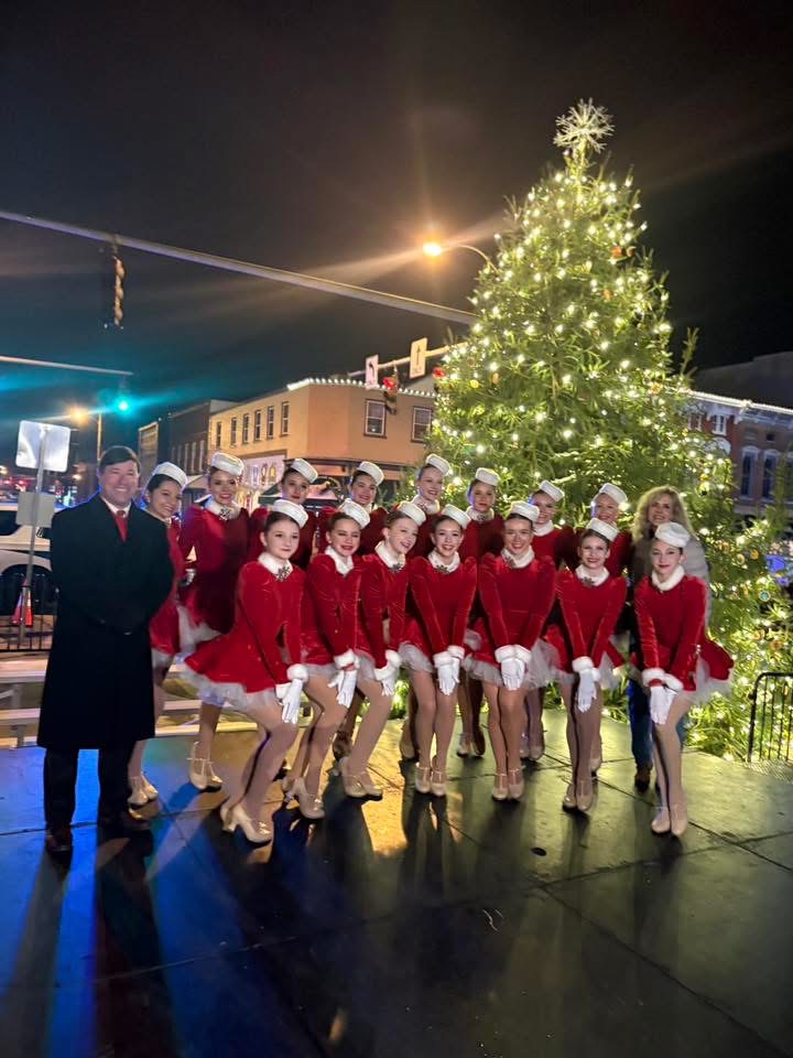 Jane's dancers take a picture in front of the Versailles Christmas tree downtown. 